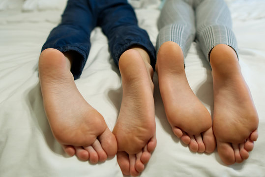 children lying in bed, kids feet close-up