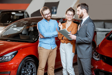 Couple with sales manager in the car dealership