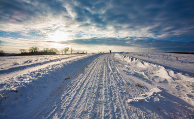 Empty snow covered road in winter landscape