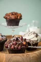Muffin Auswahl mit Blaubeeren, Walnuss, Haselnuss und Weiße Schokolade mit Milch und Zucker für Kaffeepause auf Marmor Tisch und Grün Hintergrund
