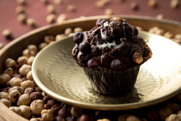 Haselnuss Muffin in Gold Messing Metall und Holz Schale mit Nüsse auf Holz Tisch Hintergrund