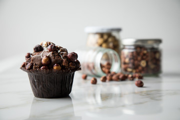 Haselnuss Muffin mit  Walnüssen und Haselnüssen in Vorrat Gläser auf Marmor Tisch hell Hintergrund