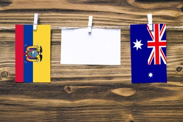 Hanging flags of Ecuador and Heard and Mcdonald Islands attached to rope with clothes pins with...