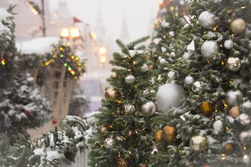 Closeup of a Christmas tree with ornaments and covered in snow - obrazy, fototapety, plakaty