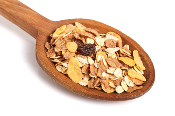 Muesli with dried fruits on wooden spoon. Isolated on white background. Macro.