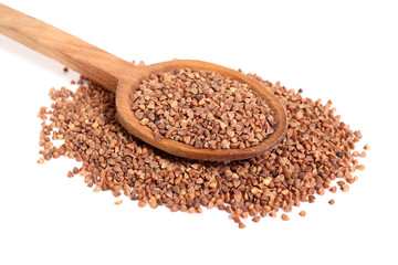Buckwheat seeds on wooden spoon. Isolated on white background.