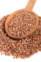 Buckwheat seeds on wooden spoon. Isolated on white background.