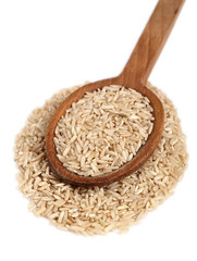 Long grain brown rice on wooden spoon. Isolated on white background.
