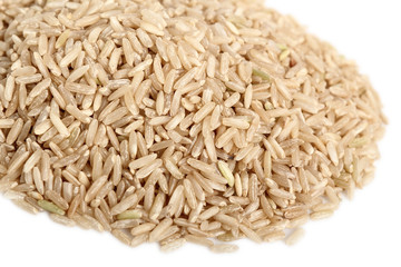 Pile of long grain brown rice. Isolated on white background. Macro.