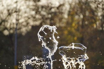 Obraz na płótnie Canvas fountain, drops of water flying in the air. screensaver, background, copy space, texture. light of the sun drops of different forms. shows for children and adults