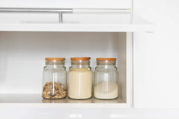 Sugar, semolina and muesli in glass jar. Food products in domestic kitchen storing. Horizontal...
