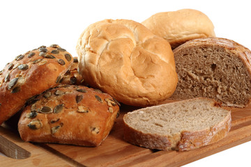 Rye bread, pumpkin and kaiser roll on cutting board. Isolated on white background.