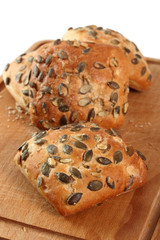 Pumpkin seed bread roll on cutting board. Isolated on white background.