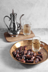 dates fruit and Arab tea on a white concrete background with a blank space for a text, dates fruit on a white background