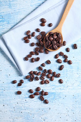 coffee bean and spoon on rustic table with a blank space for a text, coffee bean on blue background