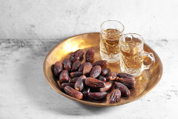 dates fruit and Arab tea on a white concrete background with a blank space for a text, dates fruit on a white background