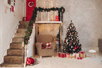 Stock photo of festive Christmas decorated interior. Garland, Christmas tree, wrapped gifts on the floor. Cozy atmosphere.