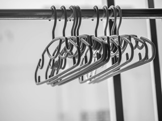 Black and white tone of stack of clothes hanger hang on aluminum clothesline, prepare for drying after laundry or washing process.