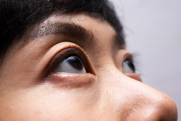 Close-up asian woman eye looking up. Eye close-up, Dark brown eye color. 
