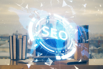 Multi exposure of table with computer and seo drawing hologram. Search optimization concept.