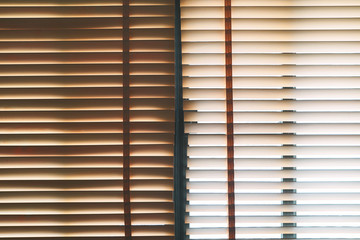Brown wooden blinds with daylight illuminating through.