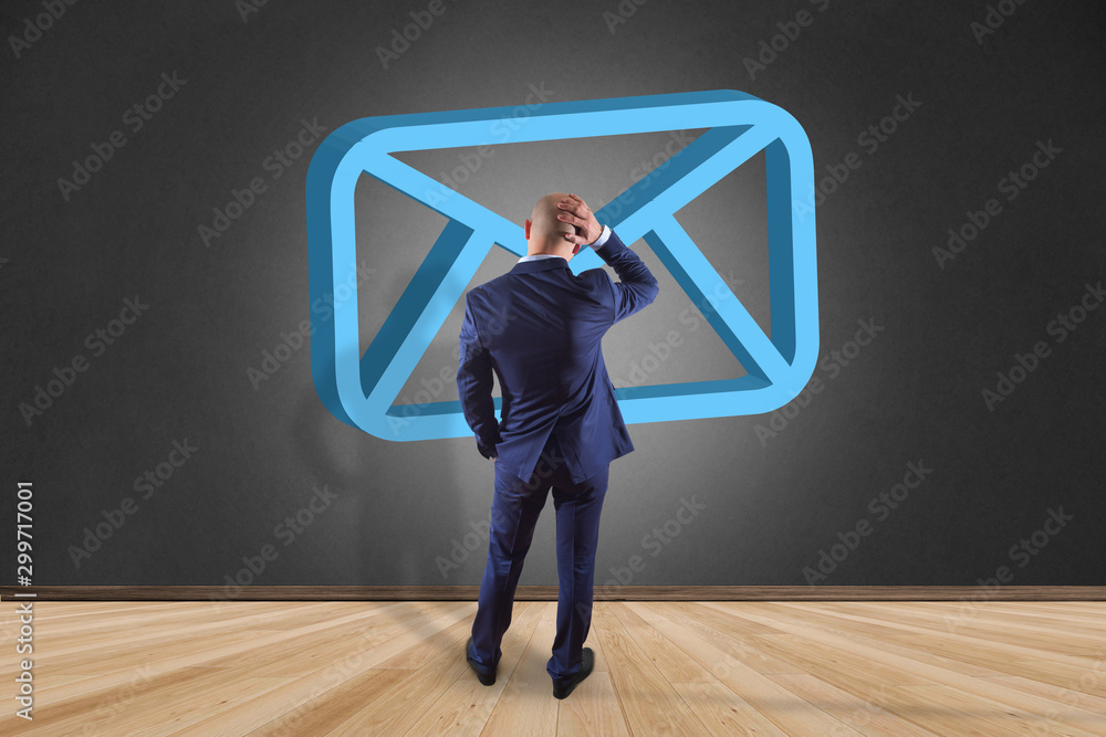Poster businessman in front of a wall with blue email symbol displayed on a futuristic interface - message 