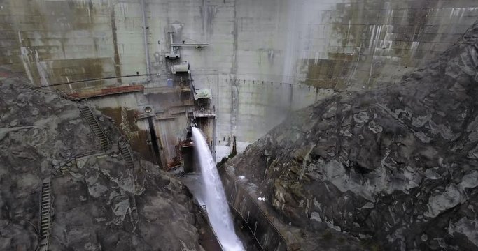 Aerial shot of a waterfall from a hydro dam in the mountains with a road from the stairs (Santa Anita Canyon, California, USA)