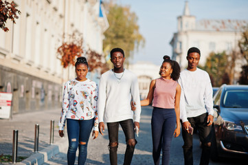 Four african friends walking the streets of an ancient city.