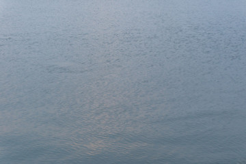 Water ripple surface reflection effect from sunset and sky top view at lake in evening day,blue nature wave abstract background