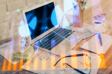 Financial chart drawing and table with computer on background. Double exposure. Concept of international markets.