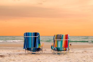 Sunset view of lounge beach chairs with towels in Siesta Key Beach of Florida Gulf Coast, USA © lucky-photo