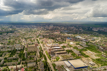 Aerial view of town or city with rows of buildings and curvy streets in summer. Urban landscape from above.