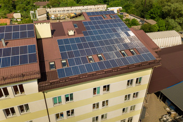 Aerial view of many solar panels mounted of industrial building roof.