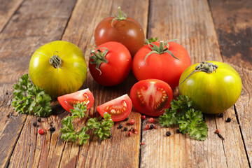 various tomato and herbs on wood background