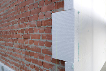 Brick house wall with rigid styrofoam insulation sheet. Modern technology of construction,...