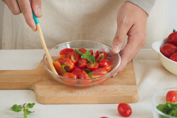 Halved juicy cherry tomatoes with fresh parsley, spices and spring onion. Home made food.
