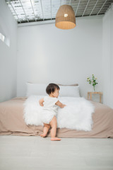 little child baby boy close up, standing near bed in bedroom