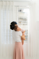 Portrait of happy vietnamese mother hugging with her cute little daughter at home