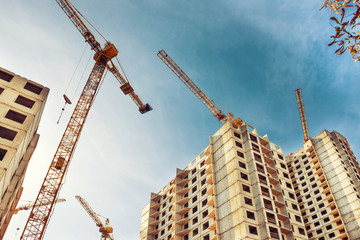 Construction site with buildings and industrial cranes