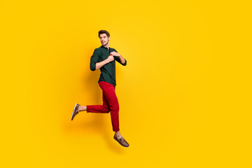 Full body profile side photo of stunning chic elegant guy feel dreamy emotions jump run on spring holidays vacation wear casual style clothing sneakers isolated over yellow color background