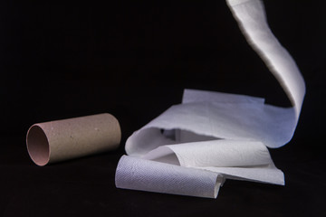close up of an unrolling of toilet paper with the empty card at the side
