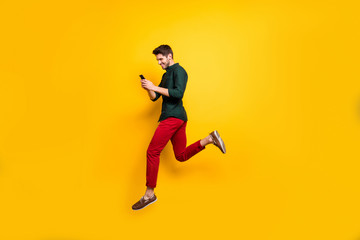Fototapeta na wymiar Profile side full length body size photo of cheerful positive man running jumping addicted to his cellphone aspiring for sales isolated bright color background