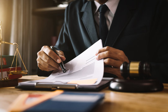 justice and law concept.Male judge in a courtroom on wooden table and Counselor or Male lawyer working in office. Legal law, advice and justice concept.