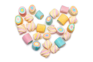 Multi-colored marshmallows laid out in the shape of a heart on a white background