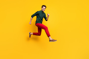 Fototapeta na wymiar Full length body size photo of cheerful positive nice cute guy running towards shopping mall isolated vivid color background