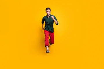 Fototapeta na wymiar Full length photo of positive cheerful funky man jump run fast hurry buy under black friday sales wear casual style clothes sneakers isolated over yellow color background