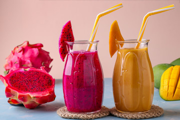 Homemade fruit smoothies made of dragon and mango on a pink background, horizontal orientation