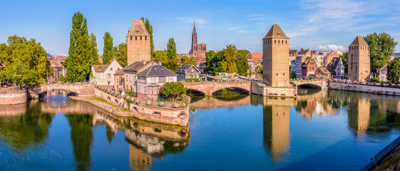 Panoramic view of the Ponts Couverts (covered bridges), a medieval set of bridges and defensive towers on the river Ill at the entrance of the Petite France historic quarter in Strasbourg, France. - obrazy, fototapety, plakaty