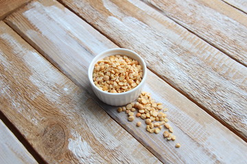 Split peas in white bowl on rustic wooden table