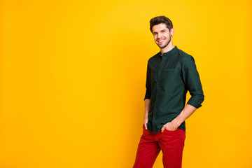 Fototapeta premium Turned photo of charming gorgeous guy have spring weekends holidays feel content emotions put hands pockets wear good looking outfit isolated over yellow color background